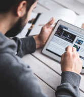 Man looking at a tablet with news.